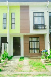 Casa amarilla y blanca con ventanas y plantas en Matina Pangi Evisa Subdivision 2 bedrooms house with parking wifi Netflix, en Davao City