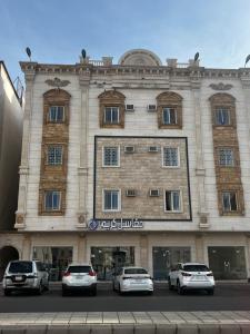 a large building with cars parked in front of it at 8 Luxury housing شقة فاخر in Al ‘Awālī