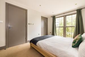 Un dormitorio con una cama grande y una ventana en Sunshine In My Mood - 2 Bedroom Flat in Battersea, en Londres
