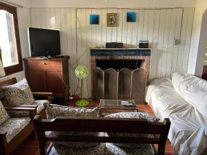 a living room with a fireplace and a tv at Pancho Villa in Barra de Valizas