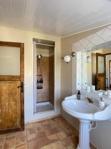 Le Mas de Mirabel في Mirabel-aux-Baronnies: حمام مع حوض أبيض ومرآة