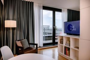 a living room with a tv and a window at THE FLAG München M. in Munich