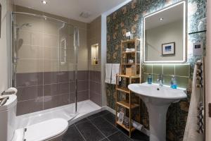 a bathroom with a shower toilet and a sink at Broad Bay House in Stornoway