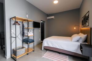 Vila Harmonia Brotas في بروتاس: غرفة نوم مع سرير ورف كتاب