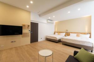 a hotel room with two beds and a tv at 靜巷19號 in Taitung City