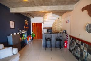 eine Küche mit einer Theke und Hockern in einem Zimmer in der Unterkunft Cabin Renty Beach in Encarnación