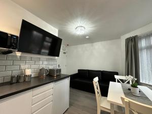 a kitchen and living room with a couch and a table at Granada Apartments Holmfield Rd in Blackpool