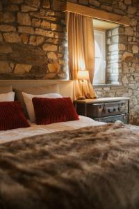 a bedroom with two beds and a stone wall at B&B La Bouliniere in Malmedy