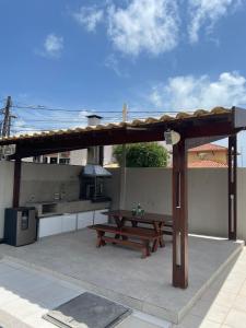 einen Picknicktisch und einen Grill auf einer Terrasse in der Unterkunft Melhores Flats - Linda casa pertinho do mar in Cabedelo + 37 Fotos