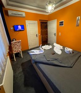 a bedroom with a bed with orange walls and a tv at Taksim Pandora hotel in Istanbul