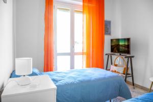 Un dormitorio con una cama azul y una ventana. en Beautiful Home 'Foeste' - With Parking - by Host4U, en Imperia