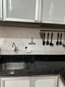 una encimera de cocina con utensilios colgados en la pared en Melhores Flats - Linda casa pertinho do mar en Cabedelo