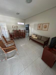 sala de estar con sillas, sofá y mesa en Melhores Flats - Linda casa pertinho do mar en Cabedelo