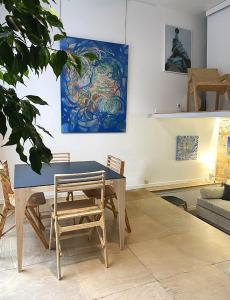 a table and chairs in a living room with a painting at Atelier d'artiste / artist loft / 35m2 in Paris