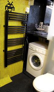 a washing machine in a bathroom with a yellow wall at Atelier d'artiste / artist loft / 35m2 in Paris