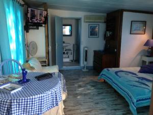 a bedroom with a bed and a table with a tableablish at L'oiseau BLEU à CALVI in Calvi