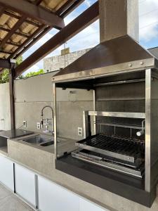 una cocina al aire libre con parrilla y fregadero en Melhores Flats - Linda casa pertinho do mar en Cabedelo