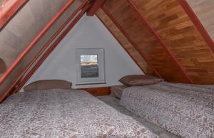 two beds in a room with a window at Villa Šola in Kupres