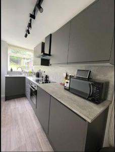 Modern 3 bedroom home, close to City Centre and Peak District في Heeley: مطبخ مع كونتر توب مع ميكروويف
