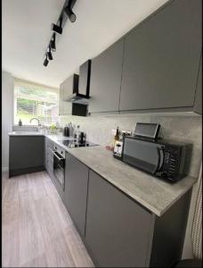 a kitchen with a counter top with a microwave at Modern 3 bedroom home, close to City Centre and Peak District in Heeley