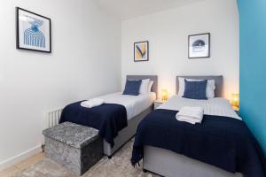 a bedroom with two beds with blue and white sheets at Air Host and Stay - St Davids House Lovely 4 bedroom house 2 bathrooms in Liverpool