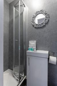 a bathroom with a shower and a sink and a mirror at Air Host and Stay - St Davids House Lovely 4 bedroom house 2 bathrooms in Liverpool