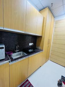 a kitchen with wooden cabinets and a sink at Gaur City Centre in Ghaziabad