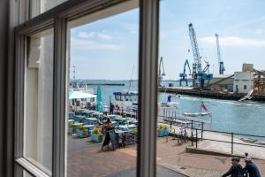 een raam met uitzicht op een haven met boten in het water bij The Old Custom House in Poole