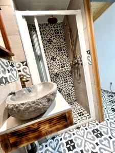 La salle de bains est pourvue d'un lavabo en pierre et d'une douche. dans l'établissement 1 Apartamento duplex con terraza y balcon a 2 calles del metro B8, à Barcelone