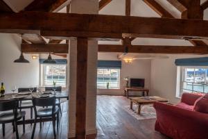 a dining room and living room with wooden beams at The Old Custom House in Poole