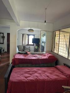 een slaapkamer met twee bedden en een spiegel bij Pancho Villa in Barra de Valizas