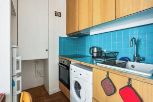 a kitchen with a sink and a washing machine at Le Cosy Pantin - France in Pantin