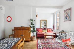 a living room with a red couch and a table at Le Cosy Pantin - France in Pantin