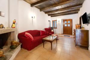a living room with a red couch and a fireplace at Casa Vacanze Laghi e Monti in Mergozzo
