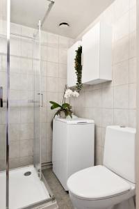 a white bathroom with a toilet and a shower at Large apartment - Luxurious neighborhood - 8 pax in Oslo