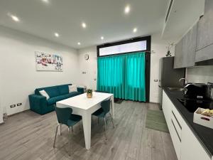 eine Küche und ein Wohnzimmer mit einem Tisch und einem blauen Sofa in der Unterkunft San Saba Street Apartment 52 in Rom