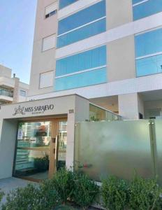 ein Gebäude mit einem Schild davor in der Unterkunft Miss Sarajevo Praia Palmas Governador Celso Ramos in Governador Celso Ramos