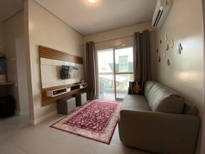 ein Wohnzimmer mit Couch und großem Fenster in der Unterkunft Miss Sarajevo Praia Palmas Governador Celso Ramos in Governador Celso Ramos