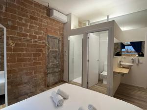 a bathroom with a brick wall and a sink at Happy People Plaza España Apartments in Barcelona