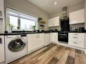 a kitchen with a washing machine in the middle at Birkdale Retreat in Southport