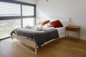 a bedroom with a bed with red and white pillows at Casa moderna y confortable en el corazón del Empordà in Colomés