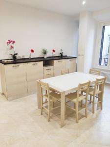 ローマにあるLuxury Suites - Stay Inn Rome Experienceのキッチン(白いテーブル、椅子付)
