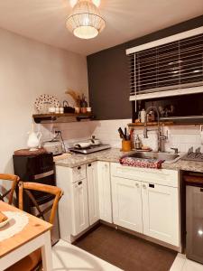 a kitchen with white cabinets and a sink at Little Cottage in Miami