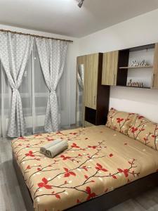 una camera da letto con un letto con fiori rossi di DAI Home a Braşov