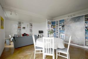 un soggiorno con tavolo, sedie e divano di Spacious apartment with 3 bedrooms - Tour Eiffel a Parigi