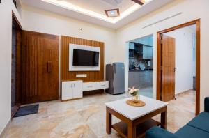 RZ Residency في بانغالور: غرفة معيشة مع تلفزيون وطاولة