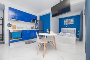 uma cozinha azul e branca com uma mesa e uma cama em T.G. Corfu Studios em Corfu Town