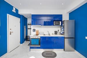 Eine blaue Küche mit blauen Schränken und einem Kühlschrank in der Unterkunft T.G. Corfu Studios in Korfu-Stadt + 32 Fotos