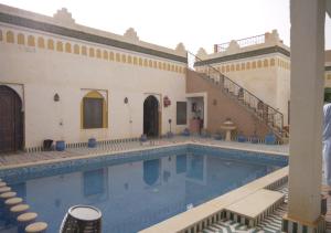 ein Pool neben einem Gebäude mit Treppen in der Unterkunft Casa laman in Merzouga