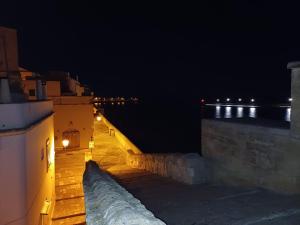 una vista notturna di un edificio con l'oceano sullo sfondo di Casa vacanze otranto a Otranto